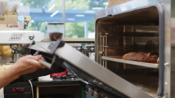 Gehakt Van Onherkenbare Bakkerijarbeider Met Mitt Openende Ovendeur Controleren Brood — Stockvideo