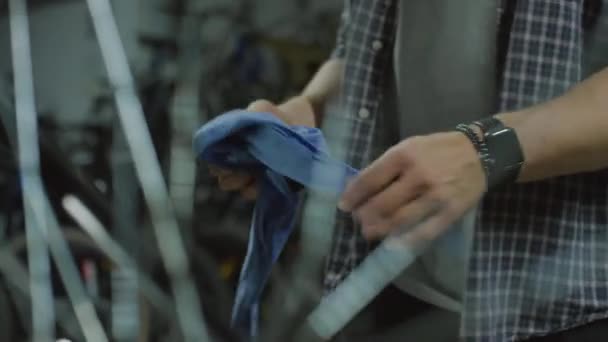 修理工場の自転車の横に立っている男性メカニックのクロップショットと仕事の後の布で手をクリーニング — ストック動画