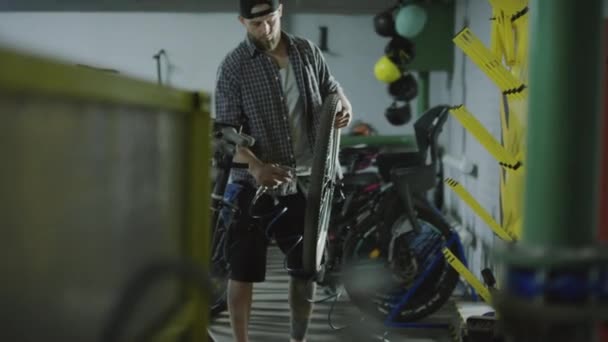 男子站在修理店用气枪清扫自行车车轮上灰尘的手持照片 — 图库视频影像