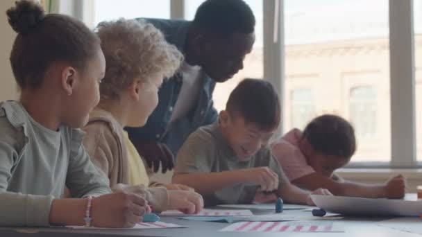 Χαρούμενα Πολυεθνικά Παιδιά Που Διασκεδάζουν Ενώ Ζωγραφίζουν Κραγιόνια Κατά Διάρκεια — Αρχείο Βίντεο