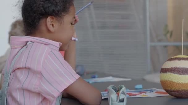 Pequena Estudante Afro Americana Sentada Mesa Com Modelo Planeta Tirando — Vídeo de Stock