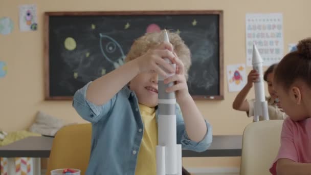 Küçük Sarışın Çocuk Kağıt Roket Yapıyor Ilkokulda Işi Yaparken Sınıf — Stok video