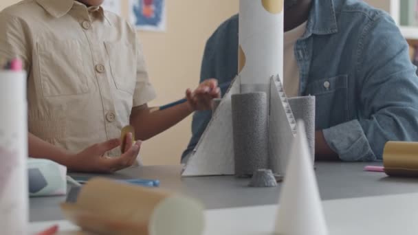 非洲裔美国小女孩提起太空火箭模型 在小学课堂上与男教师交谈时的倾斜镜头 — 图库视频影像