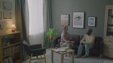 Kadın uyku doktorunun Afrikalı Amerikalı erkeğe klinikte danışmanlık yaparken uykusuzlukla başa çıkmak için nefes alma egzersizleri öğretmesi.