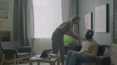 Uyku doktoru, siyah erkek hastanın başına elektrotlar takıyor, sonra da klinikteki EEG testinde dizüstü bilgisayar alıyor ve beyin aktivitelerini izliyor.