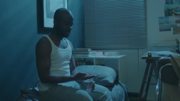 Μαύρος Που Κάθεται Στο Κρεβάτι Στο Σκοτεινό Δωμάτιο Παίρνει Υπνωτικά — Αρχείο Βίντεο