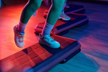 Beden eğitiminde adım platformunda egzersiz yapan kimliği belirsiz sporcu.