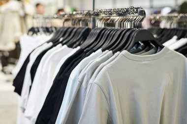 Dükkandaki elbise askılarında asılı tişörtlerin yakın plan fotoğrafı.