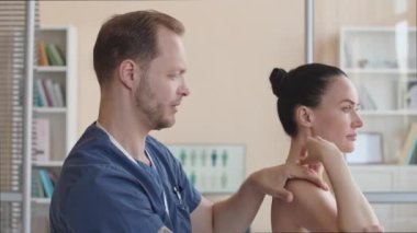 Klinikteki doktor randevusu sırasında kadın hastaların kol bükme ve muayene kaslarını elle tedavi etme