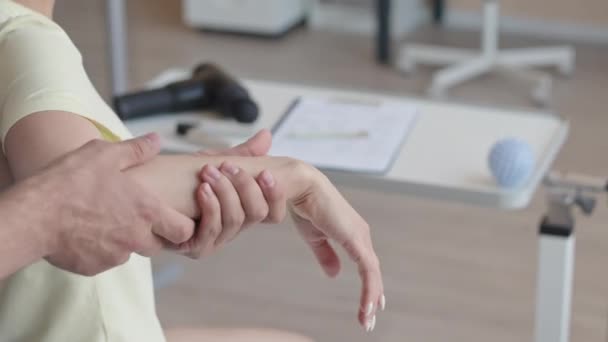 클리닉에서 검사하는 만지고 환자의 손목을 구부리는 치료사의 — 비디오