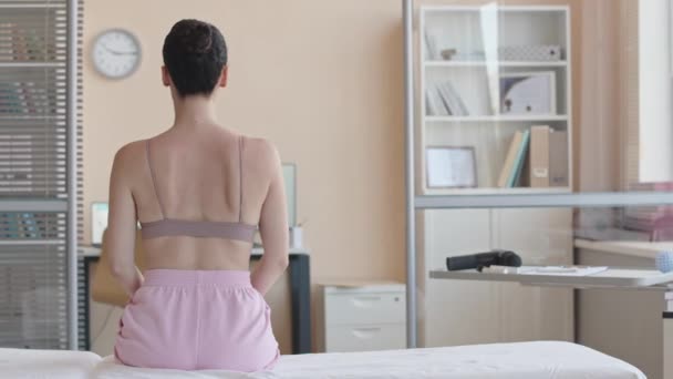 Vista Posterior Paciente Sin Camisa Sentada Sofá Médico Clínica Fisioterapia — Vídeo de stock