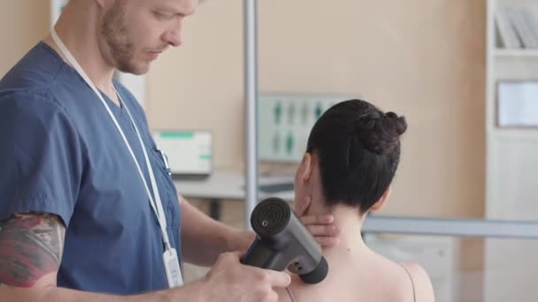 Vystřižený Snímek Profesionálního Fyzioterapeuta Použitím Masážní Pistole Zádech Pacientky Během — Stock video