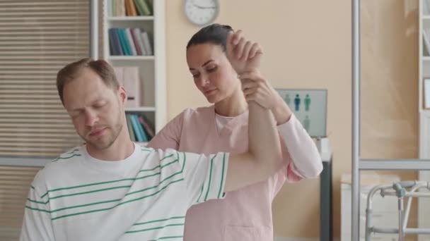 Kadın Fizyoterapist Klinikte Tıbbi Danışmanlık Sırasında Erkeğin Omzunu Muayene Ediyor — Stok video