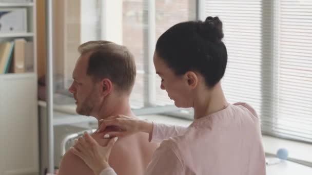 Shirtless Man Sitter Medicinsk Soffa Kliniken Och Visar Var Spänningen — Stockvideo