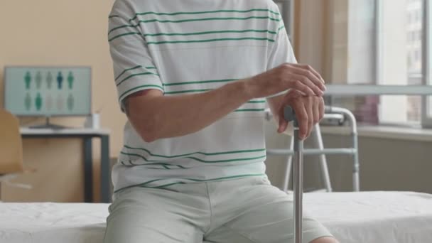 Ujęcie Środkowe Nierozpoznawalnego Mężczyzny Siedzącego Kanapie Lekarskiej Klinice Fizjoterapii Trzymającego — Wideo stockowe