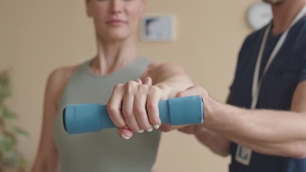 Крупный План Пожимания Руки Женщины Держащей Гантель Поддержке Физиотерапевта Мужчины — стоковое видео