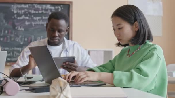 동료와 교실에서 책상에 프로그래밍을 배우는 노트북에 아시아 소녀의 — 비디오