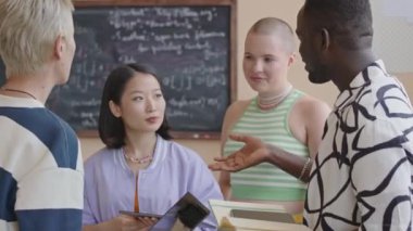 Üniversitedeki programlama dersi sırasında çok ırklı akran grubunun tartışıp gülümsemesini yakınlaştır.