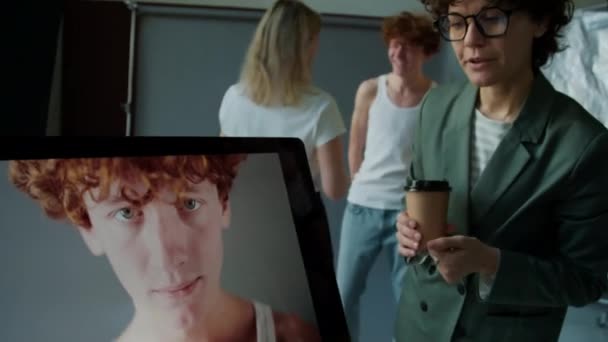 Kadın Sanat Yönetmeni Erkek Modelin Fotoğrafçıyla Bilgisayar Ekranında Fotoğraf Çekerken — Stok video