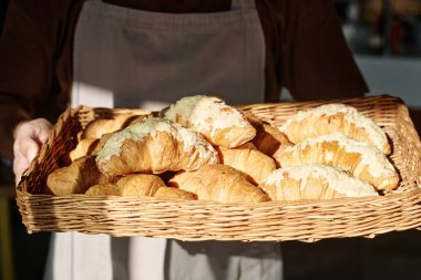 Hasır tepsiyi taze hamur işiyle tutan kimliği belirsiz adamın yakın çekimi.