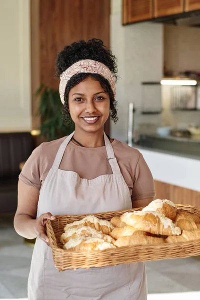 Medium shot of african american cafe worker posing at her workplace with fresh pastry