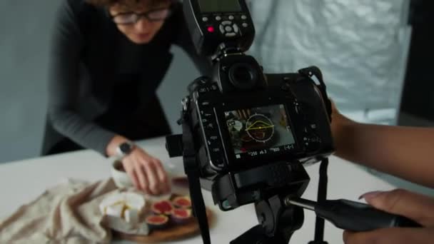 스튜디오 촬영하기 테이블에 음식을 준비하는 스타일리스트로 디지털 카메라를 작가의 — 비디오