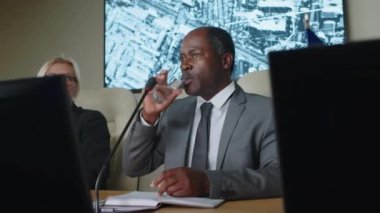 Uluslararası zirvede gazetecilerin sorularını yanıtlarken konuşma ve içme suyu veren Afrikalı Amerikalı ülke lideri