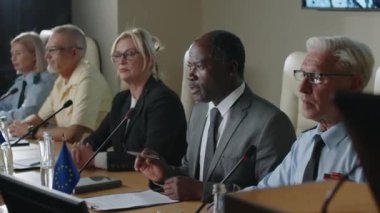 Afro-Amerikalı siyasi lider kamuoyu açıklaması yapıyor ve çok ırklı askeri basın konferansına katılanları alkışlıyor