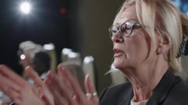 Siyasi basın toplantısına öncülük ederken mikrofon başında duran ve konuşma yapan kıdemli kadın.