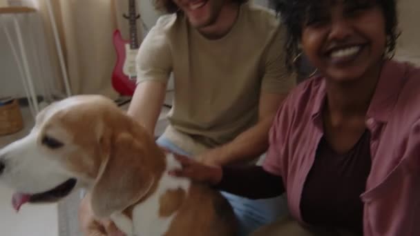 年轻迷人的比利西亚女人与她的高加索男友和他们可爱的小猎犬在家里玩得开心地一起录音的手持Pov — 图库视频影像