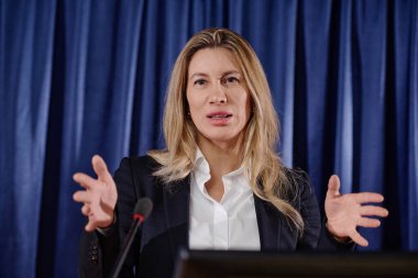 Konferanstaki performansı sırasında konuşmacı mikrofonla konuşmasını yapıyor.