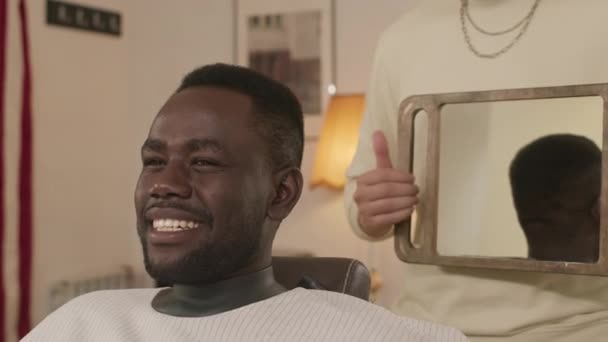 Genç Neşeli Siyah Adam Aynaya Bakıyor Berberin Tuttuğu Aynaya Gülümsüyor — Stok video