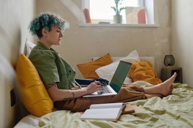 Protez kollu liseli kız sınav için internetten çalışıyor.