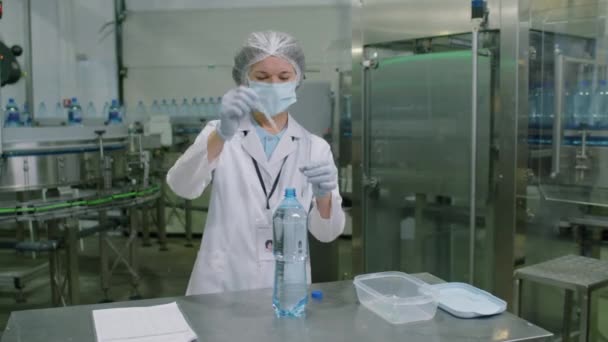 Koruyucu Eldivenli Maskeli Kadın Kimyagerin Şişeleme Tesisinde Çalışan Örneği Alırken — Stok video