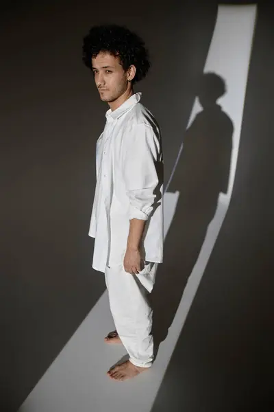 暗いスタジオで光線で立っている若者のフルショット — ストック写真