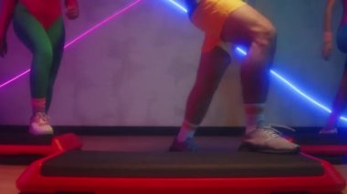 Stüdyoda neon ışıklarıyla aerobik yaparken dizlerinin üstüne çöküp...