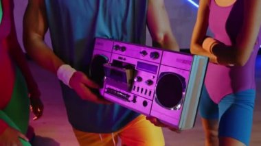 Arkadaşların müzik kutusunu açıp dans etmelerini, neon stüdyodaki eski kıyafetlerin aerobik eğitiminden sonra dinlenmelerini.