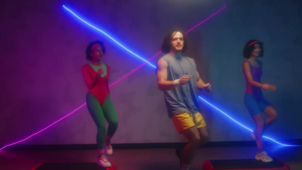 Neon Işıklarıyla Aerobik Dersinde Çift Irklı Sporculardan Oluşan Bir Takımın — Stok video