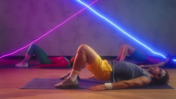 Spor Yapanların Retro Aktivite Kıyafetleri Içinde Geniş Neon Stüdyoda Egzersiz — Stok video