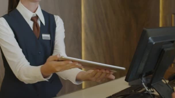 호텔에서 체크인하는 디지털 태블릿에 서명을하고 리셉션 담당자에게 감사하는 — 비디오