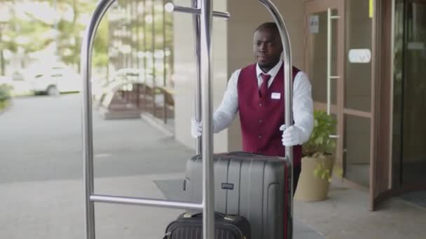 Genç Afro Amerikalı Üniformalı Komi Otelin Dışında Valiz Arabasında Valiz — Stok video
