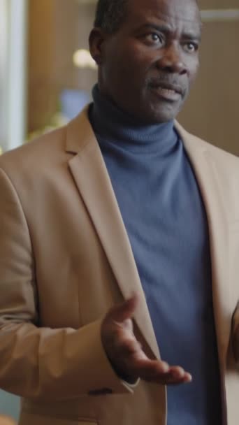 Függőleges Dőlésszögű Felvétel Középkorú Fekete Férfi Formális Öltönyben Áll Szállodában — Stock videók