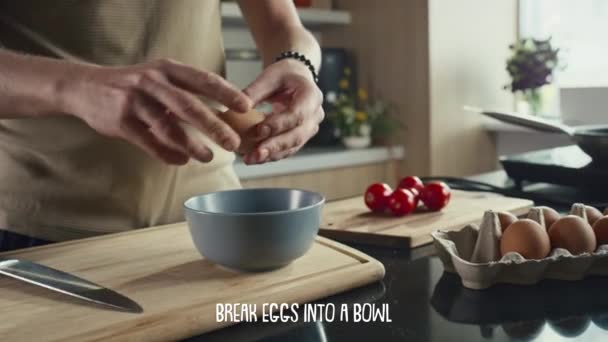 朝食を作っている間 ボウルに卵を割る男性シェフの手の近くのショット 下に表示されるレシピのステップを記述する字幕 — ストック動画