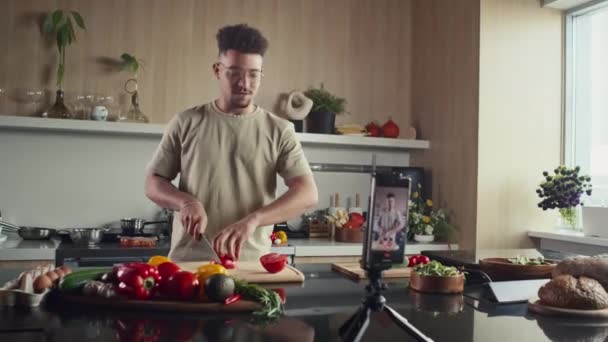 Młody Blogger Żywności Cięcia Pomidorów Przy Stole Kuchni Mówienie Aparacie — Wideo stockowe