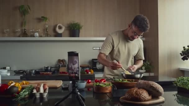 在拍摄社交媒体视频菜谱的同时 年轻的食物博客作者在智能手机相机上做煎蛋卷和展示煎锅 — 图库视频影像