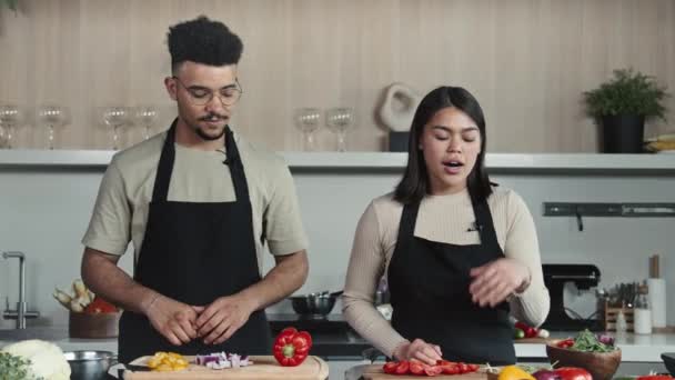 Genç Erkek Kadın Şeflerin Önlükleriyle Mutfakta Durup Sebze Gösterirken Yemek — Stok video