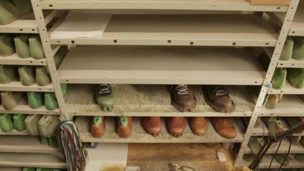 ワークショップで靴を履いたコブラーのショットは シェルフに持続し ワークデー中にブーツを作っている間に接着剤を使用します — ストック動画