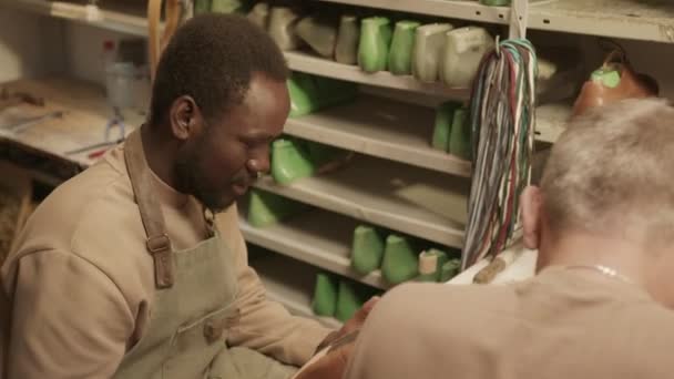 Jovem Aprendiz Negro Reparando Sapato Conversando Com Sapateiro Sênior Enquanto — Vídeo de Stock
