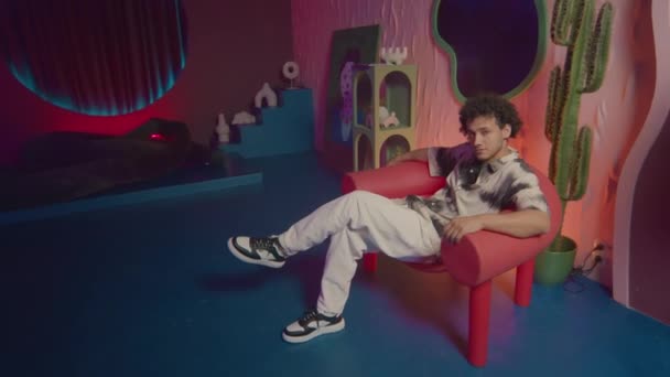 Junger Mann Sitzt Pop Art Sessel Und Posiert Trendig Gestalteten — Stockvideo