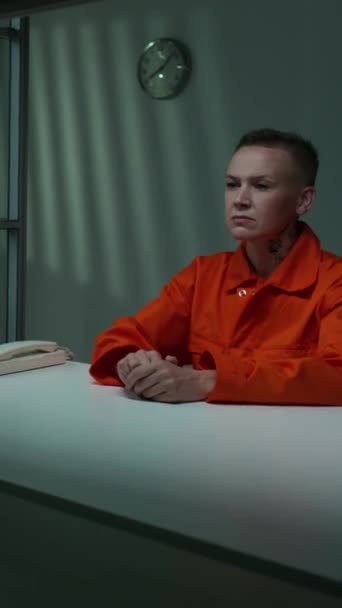 Vertikální Záběr Zatčené Krátkovlasé Ženy Oranžové Vězeňské Uniformě Sedící Stolu — Stock video